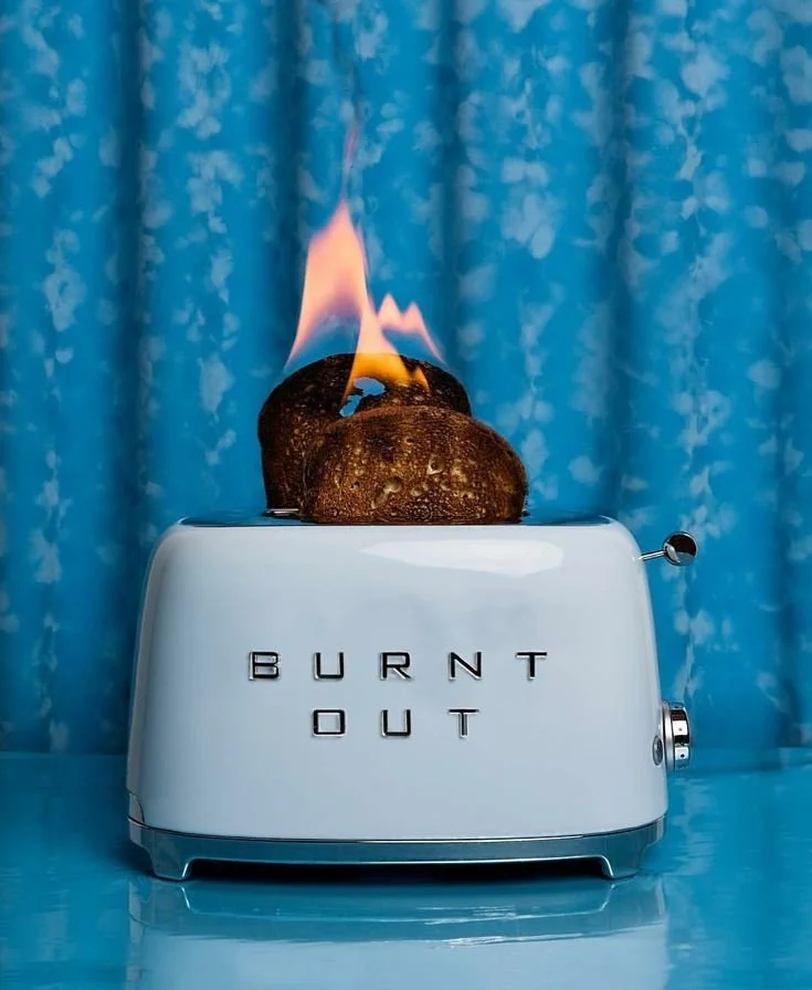 Creative visual metaphor of burnout shown through burning toast in a retro toaster — commentary on overwork and modern lifestyle culture.
