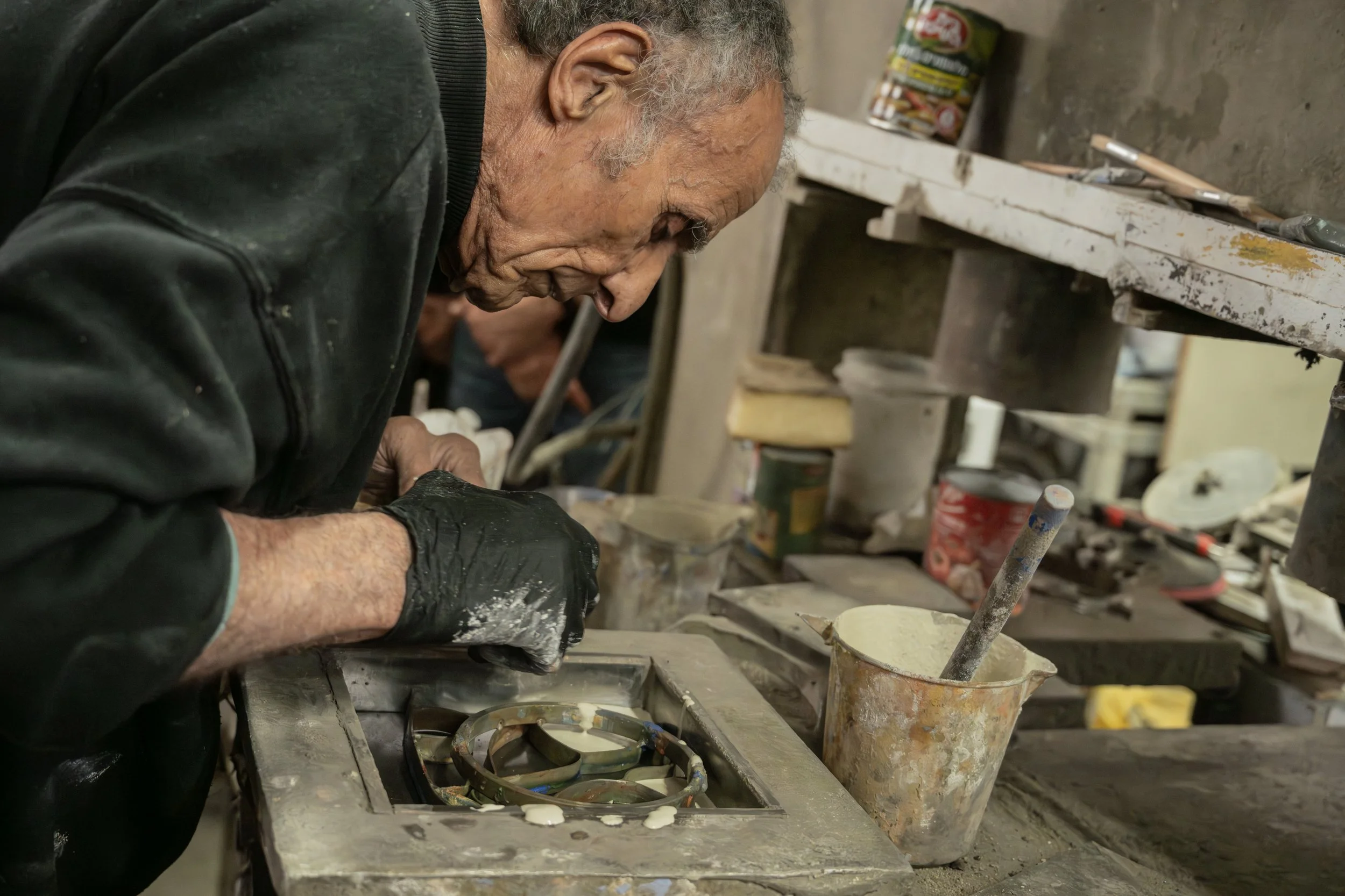 Avner Gluska leaning over his workbench
