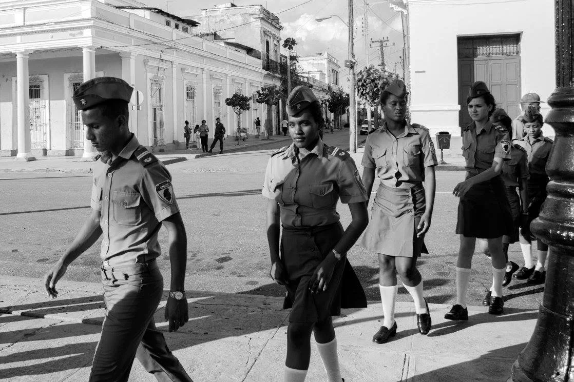 חיילות וחיילים צועדים בצעד אחיד לאורך השדרה, בצילום שחור־לבן