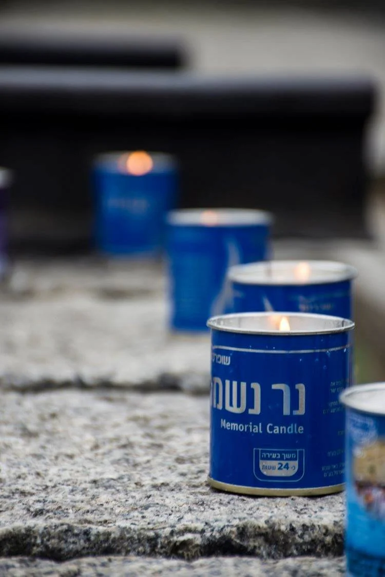 נרות זיכרון כחולים דולקים עם כיתוב בעברית