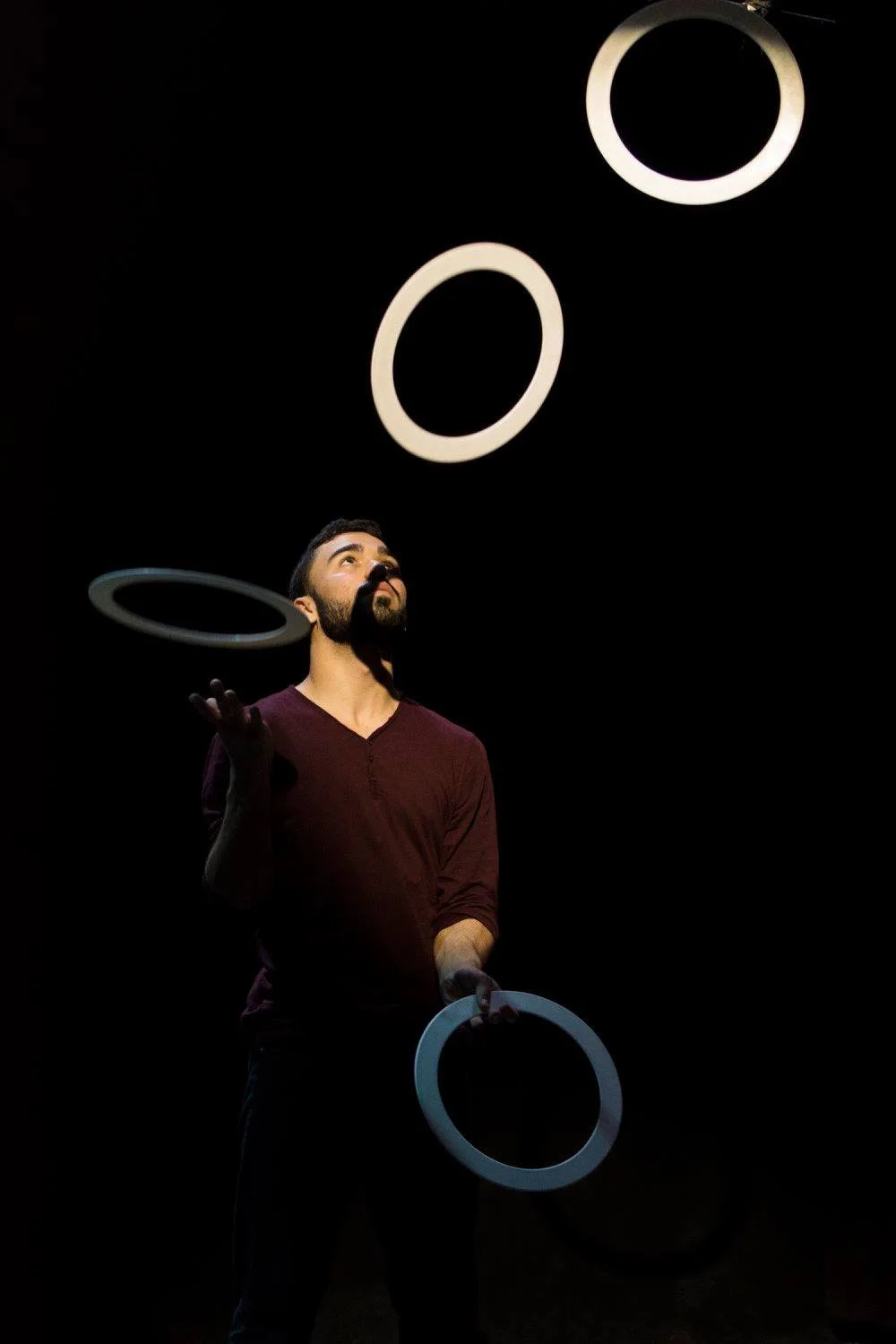 להטוטן זורק וטופס טבעות לבנות מתחת לזרקור ברגע האמצע