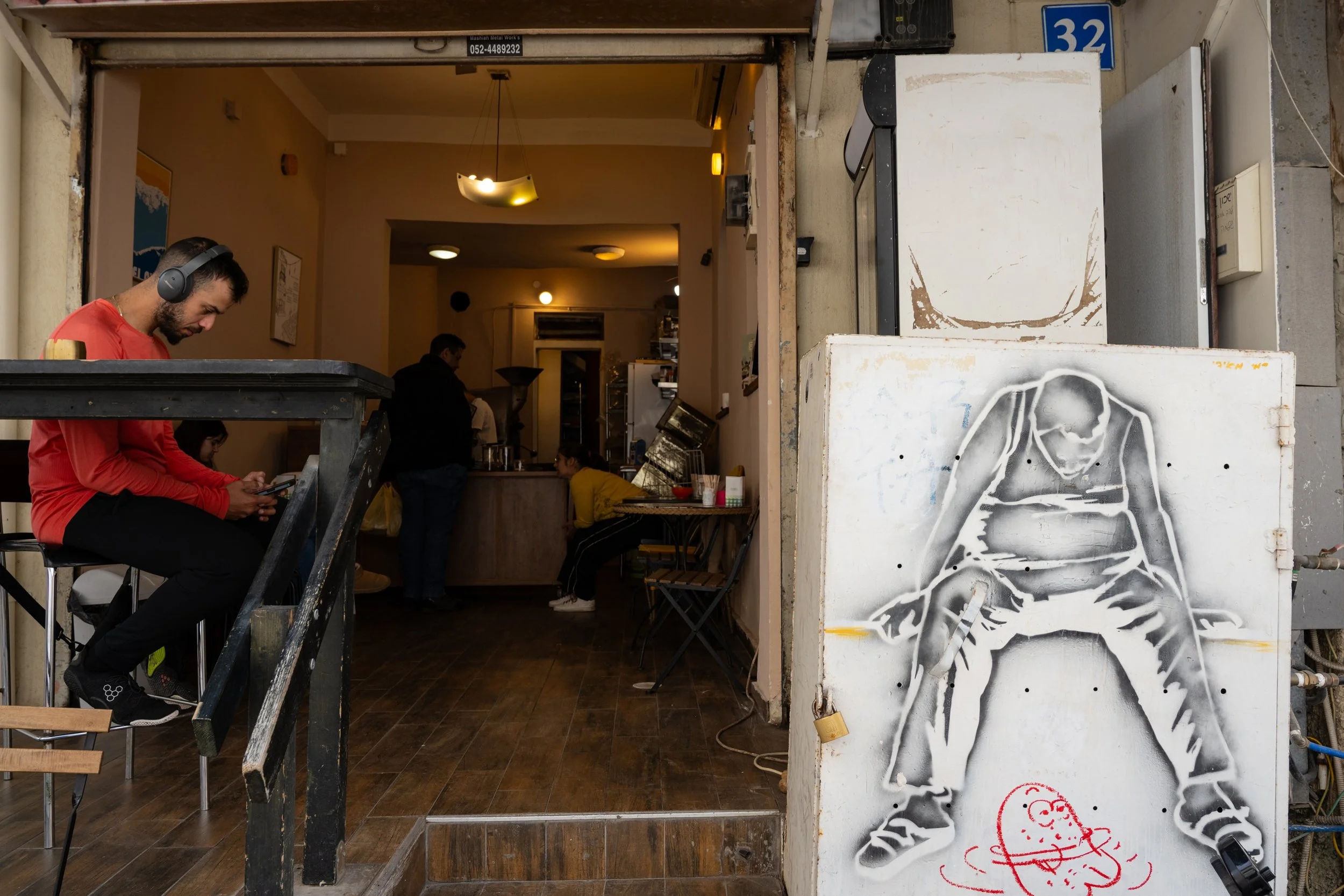 Graffiti-covered entrance to a small bar near Carmel Market