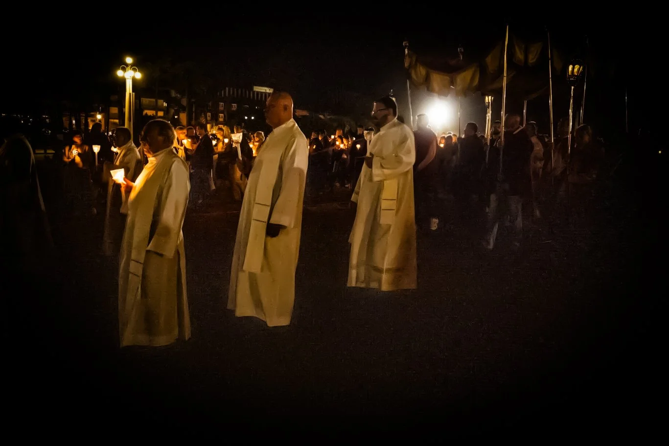 Nighttime religious procession in Fátima with candle-bearing participants moving through the dark