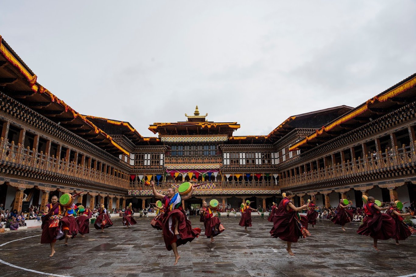 בחצר הדזונג, רקדנים במסכות מסתחררים ותופי הטקס עולים, ממלאים את המרפסות המגולפות בצבע וברעם – טימפו, בהוטן