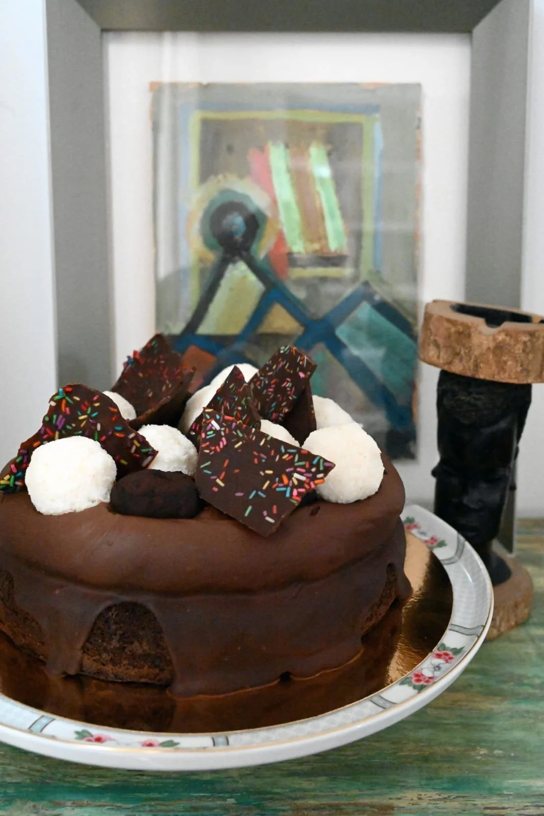 עוגת שוקולד עשירה מקושטת בפרלינים, כדורי קוקוס ושברי שוקולד מצופים בסוכריות צבעוניות