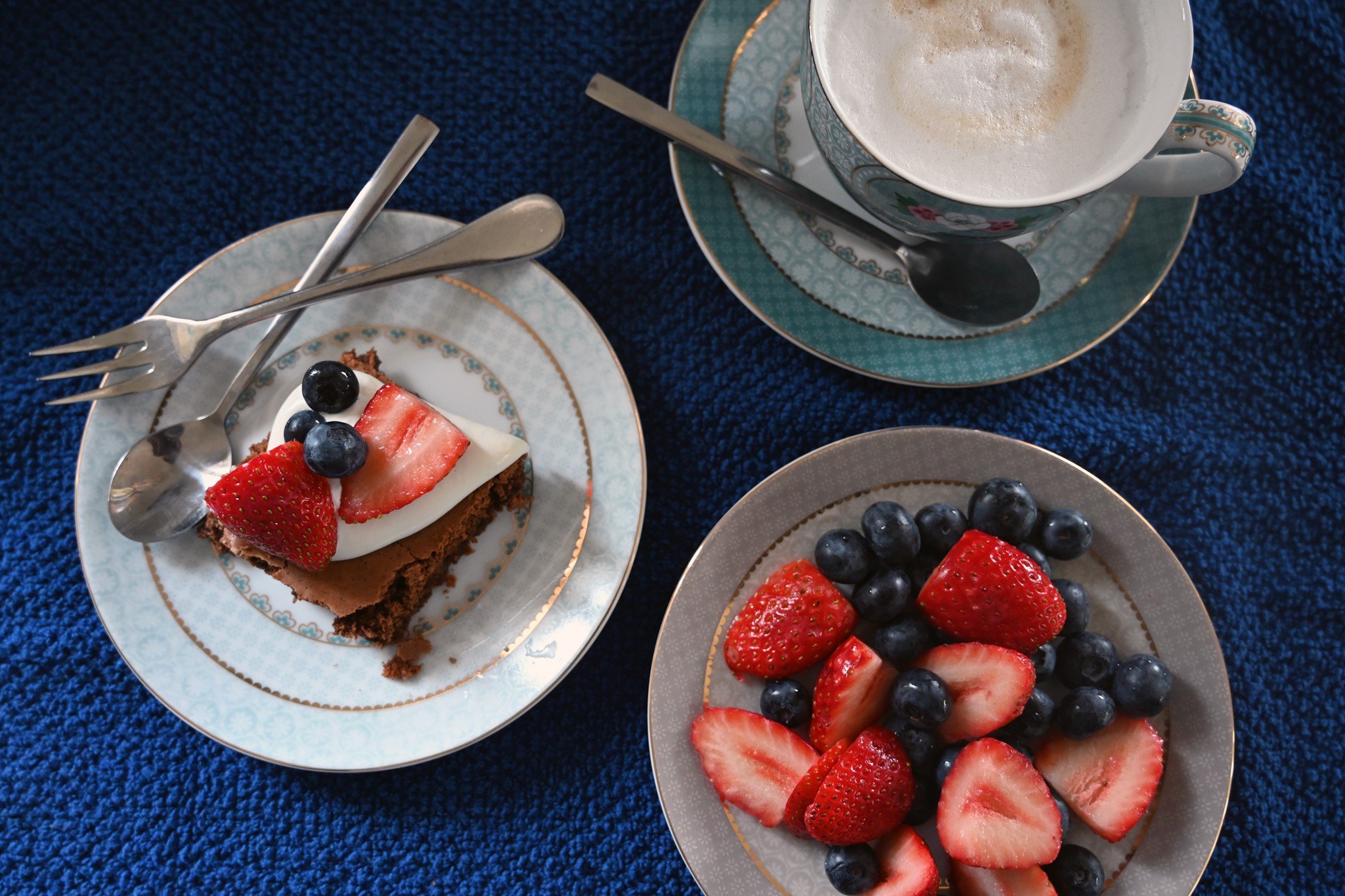 מתיקות של בוקר – פירות יער, עוגה וקפה שמתכנסים יחד על מפה כחולה