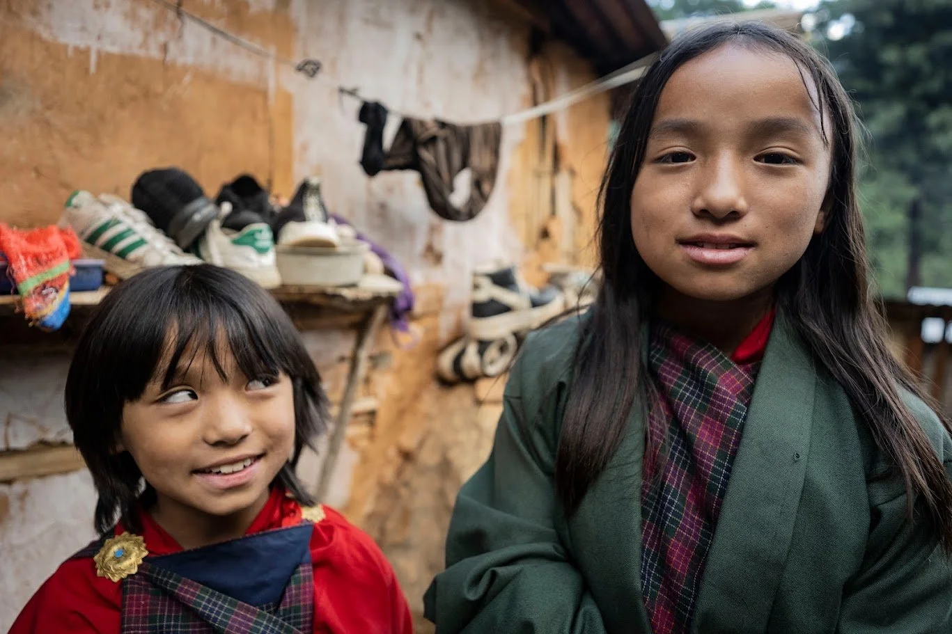 שתי ילדות בבגדים מסורתיים מחייכות למצלמה – בהוטן