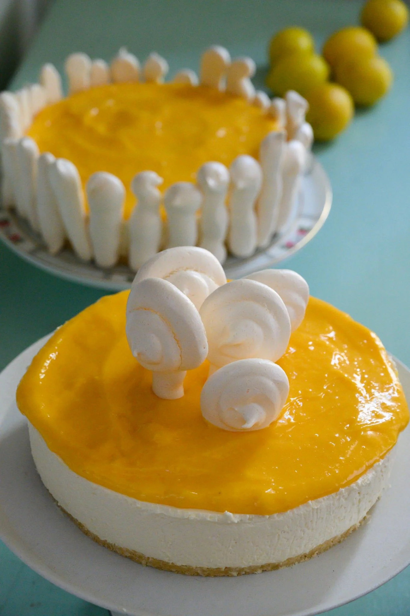 עוגת גבינה בציפוי קרם לימון זוהרת כמו שמש, מעוטרת בסחרורי מרנג שובבים