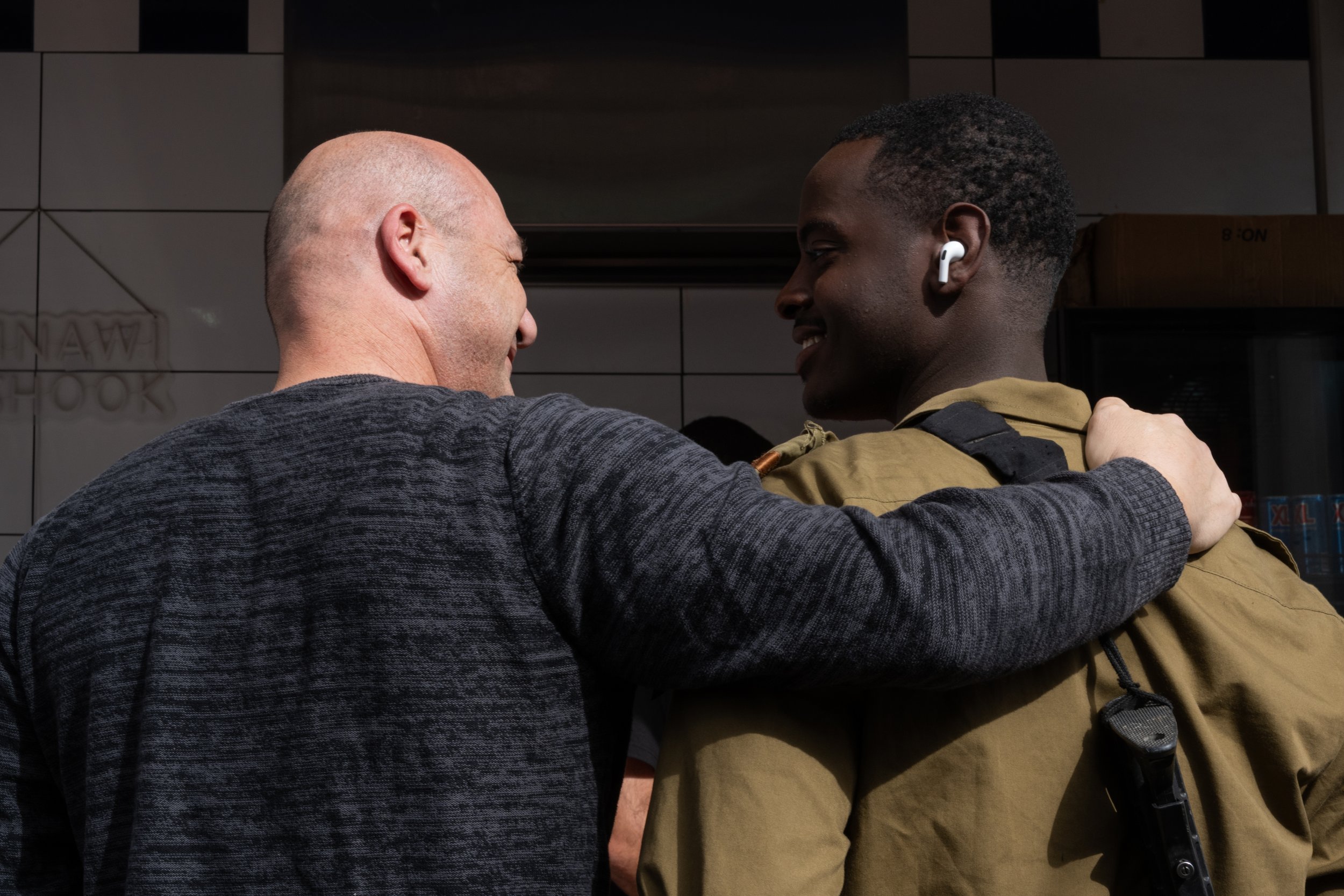 A moment of closeness between two people at Carmel Market in Tel Aviv