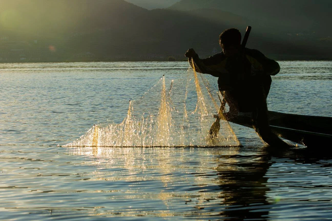 רשת נפרשת באוויר כשהשמש שוקעת מעל המים – אגם אינלה, מיאנמר