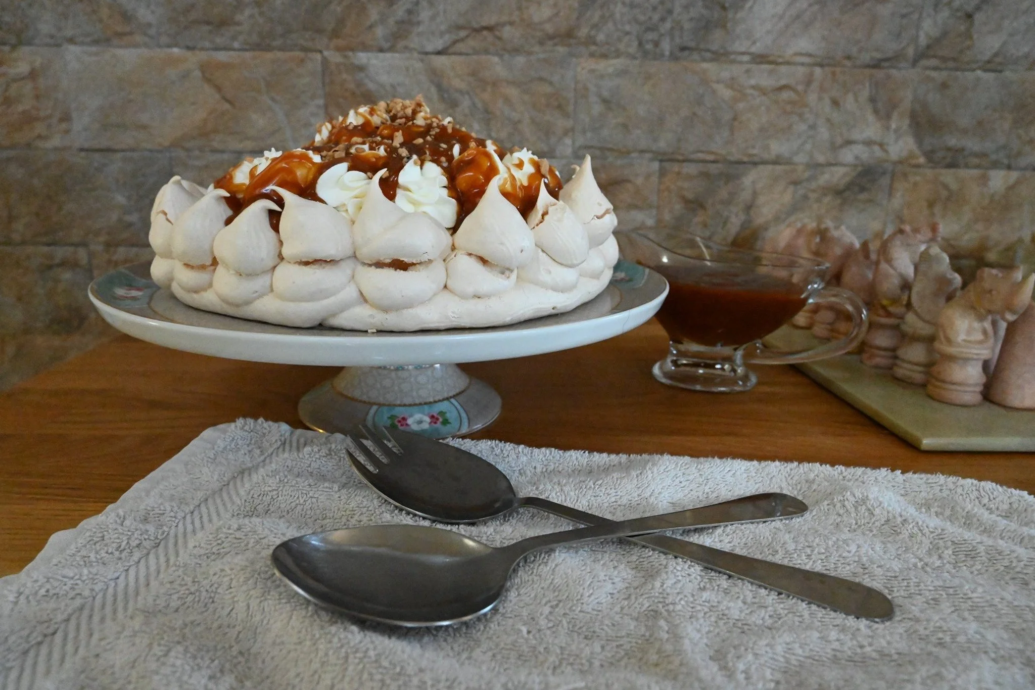 פבלובה קרמל מלוח על הסטנד שלה, קנקן רוטב וכפות גדולות מחכות שכולם יצללו פנימה