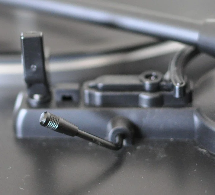 Close-up of a turntable tonearm and cartridge on a record player.