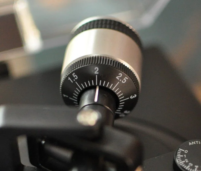 Close-up of a metallic mechanical timer with a black dial and white marking, set on approximately 1 second.