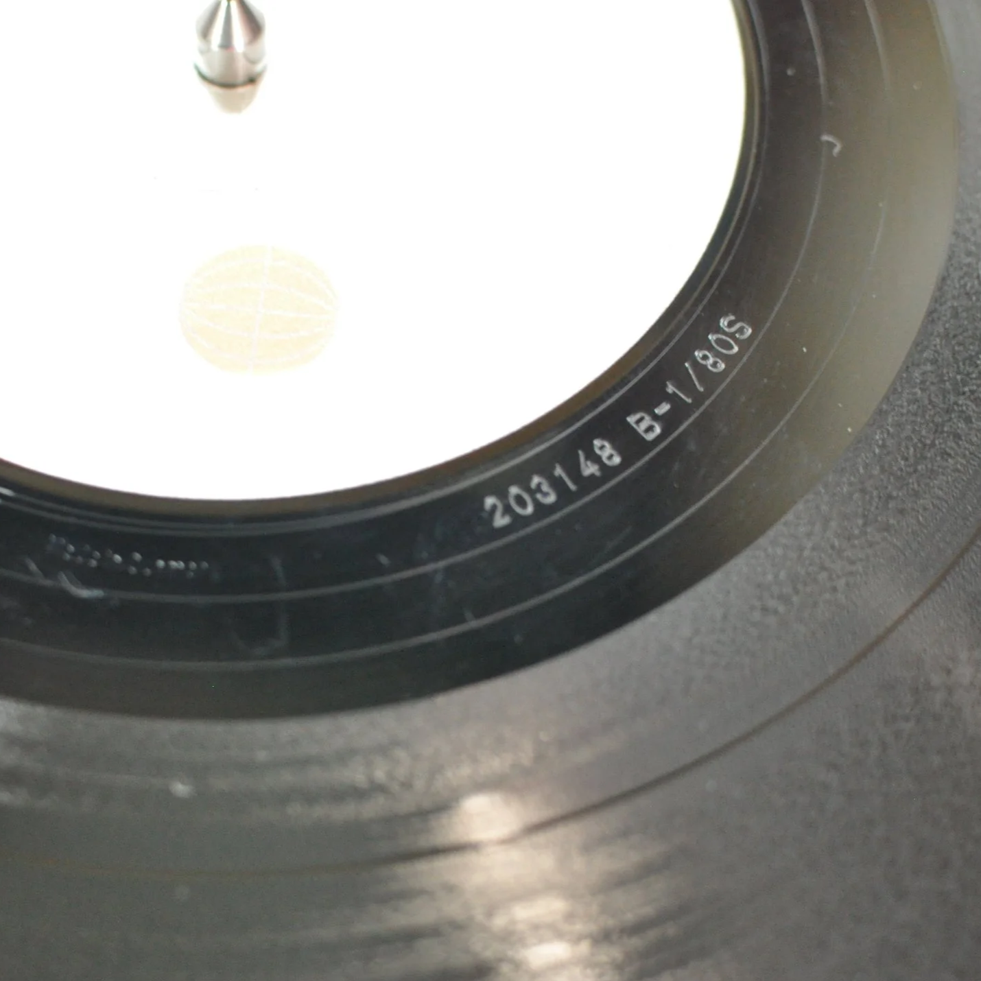 Close-up of a camera lens showing serial number 203148 B-1805 engraved on the black rim.