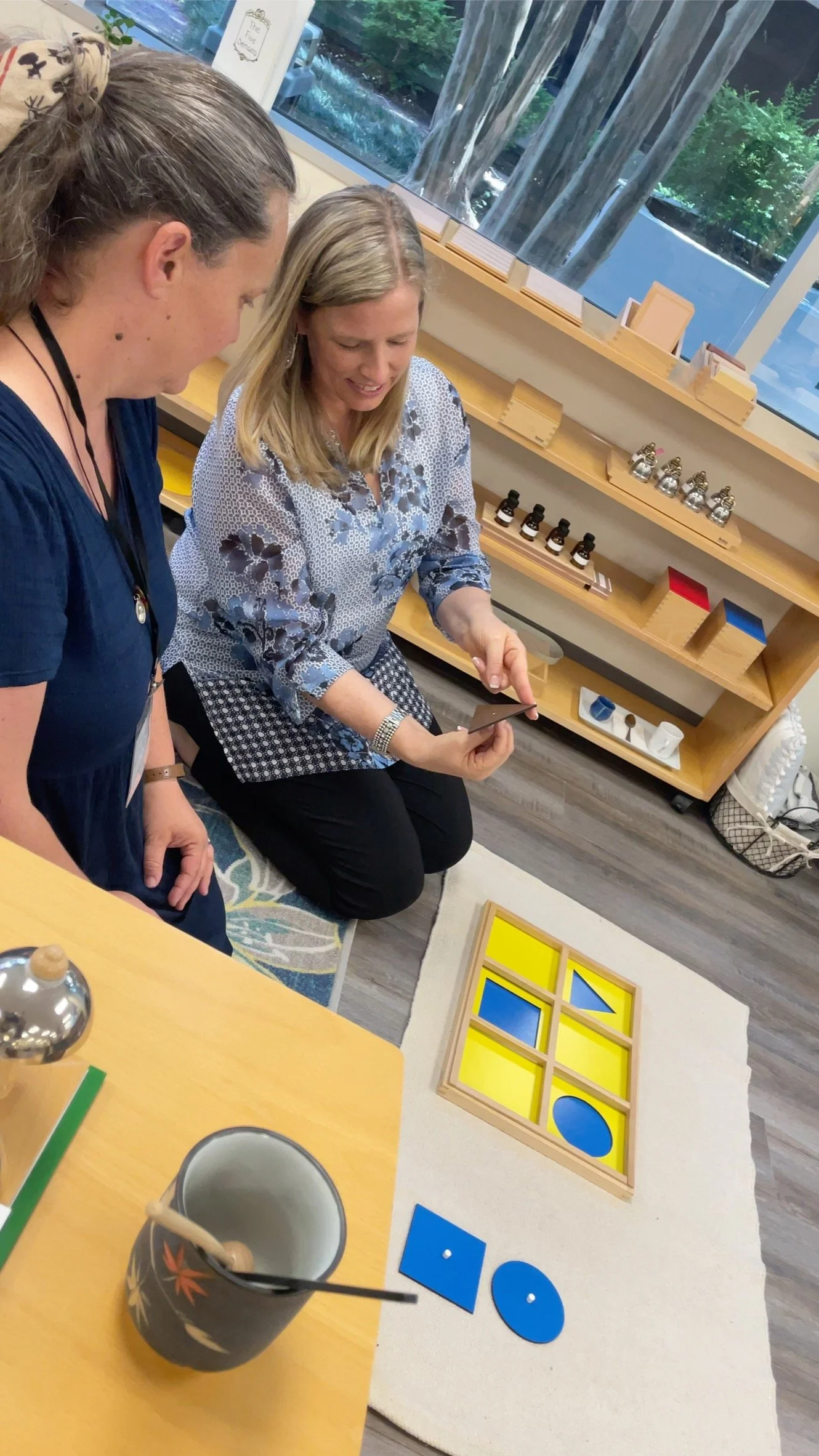 Four women are gathered around Sensorial Materials in a Montessori Training Center, MINT
