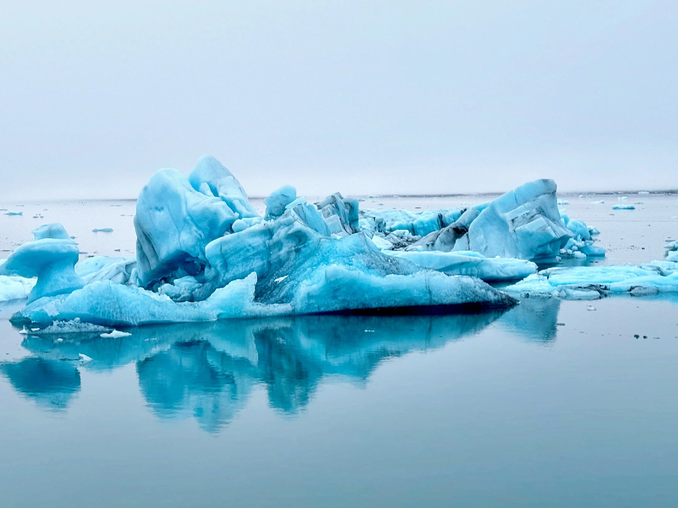 Icebergs floating in calm water on a cloudy day. Iceland