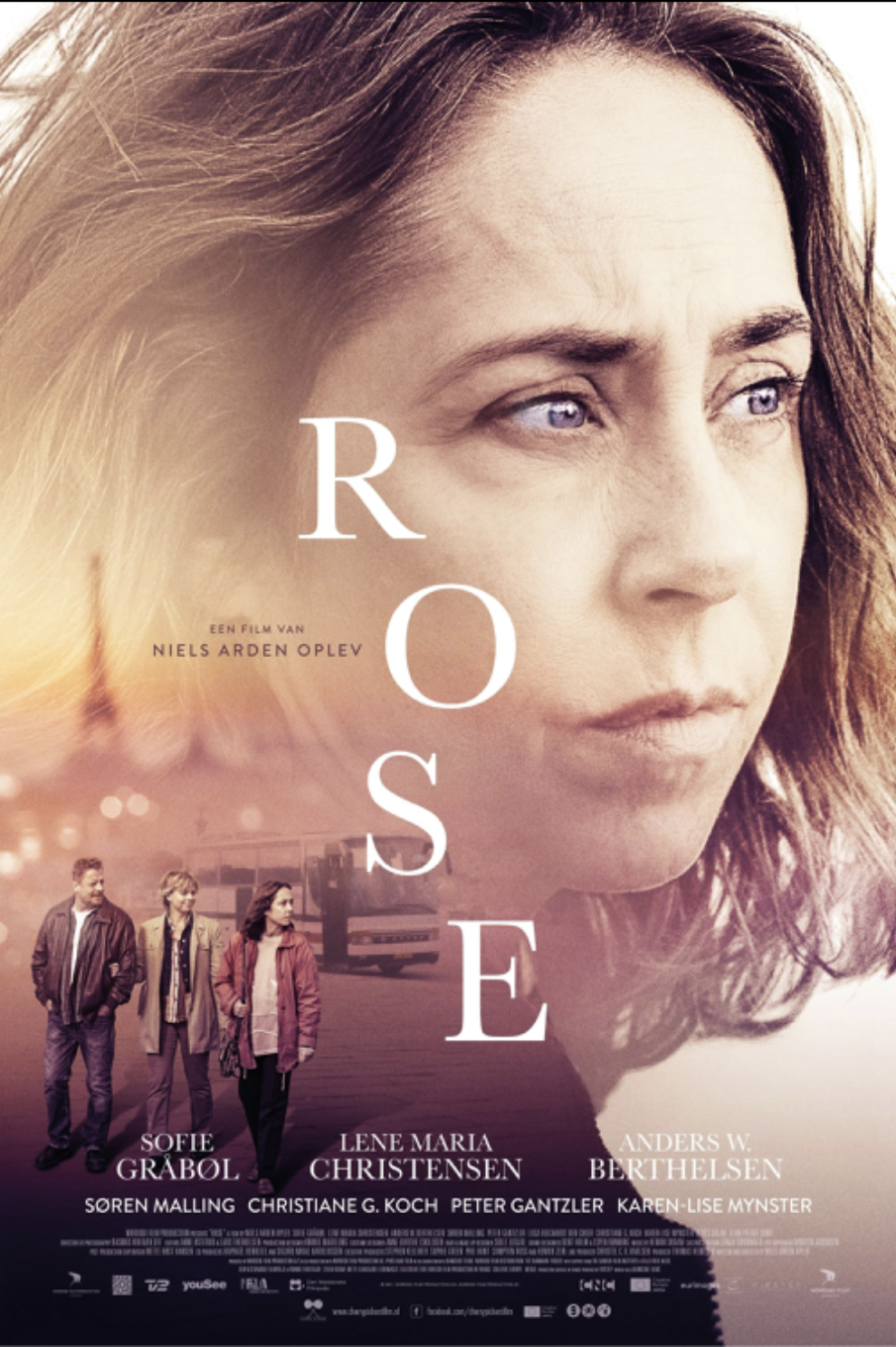 Movie poster for 'Roses' featuring a close-up of a woman with light brown hair and blue eyes, and three people walking in the background near a bus.