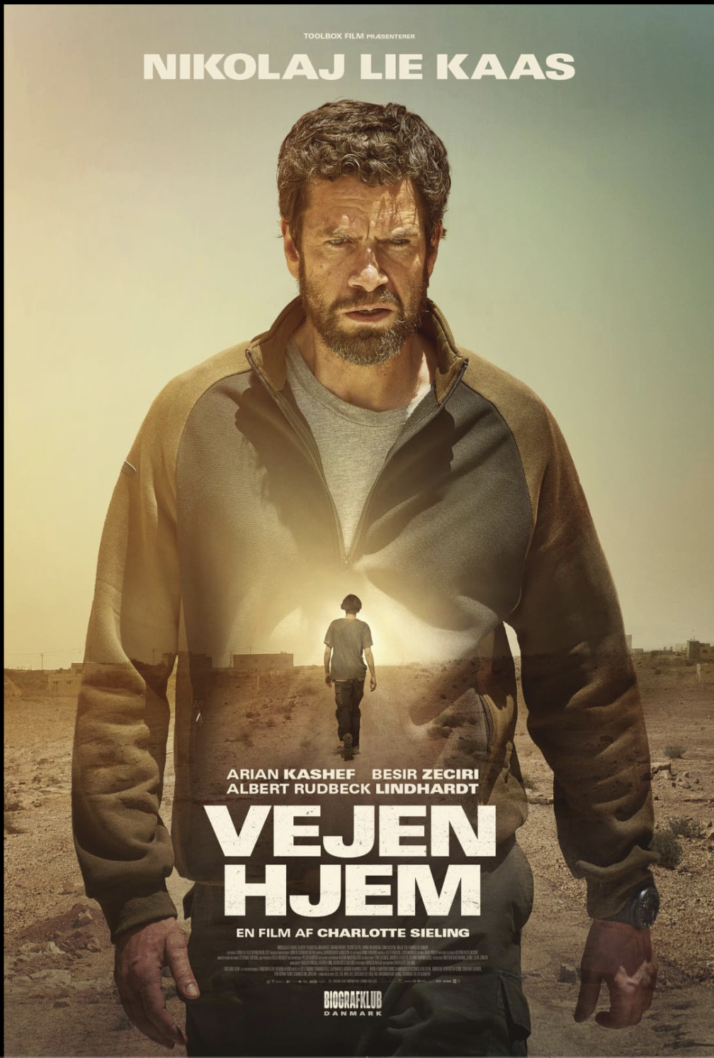 Movie poster for 'Vejene Hjem' featuring a man with a serious expression, standing in a desert landscape, with a smaller figure walking away towards the horizon.