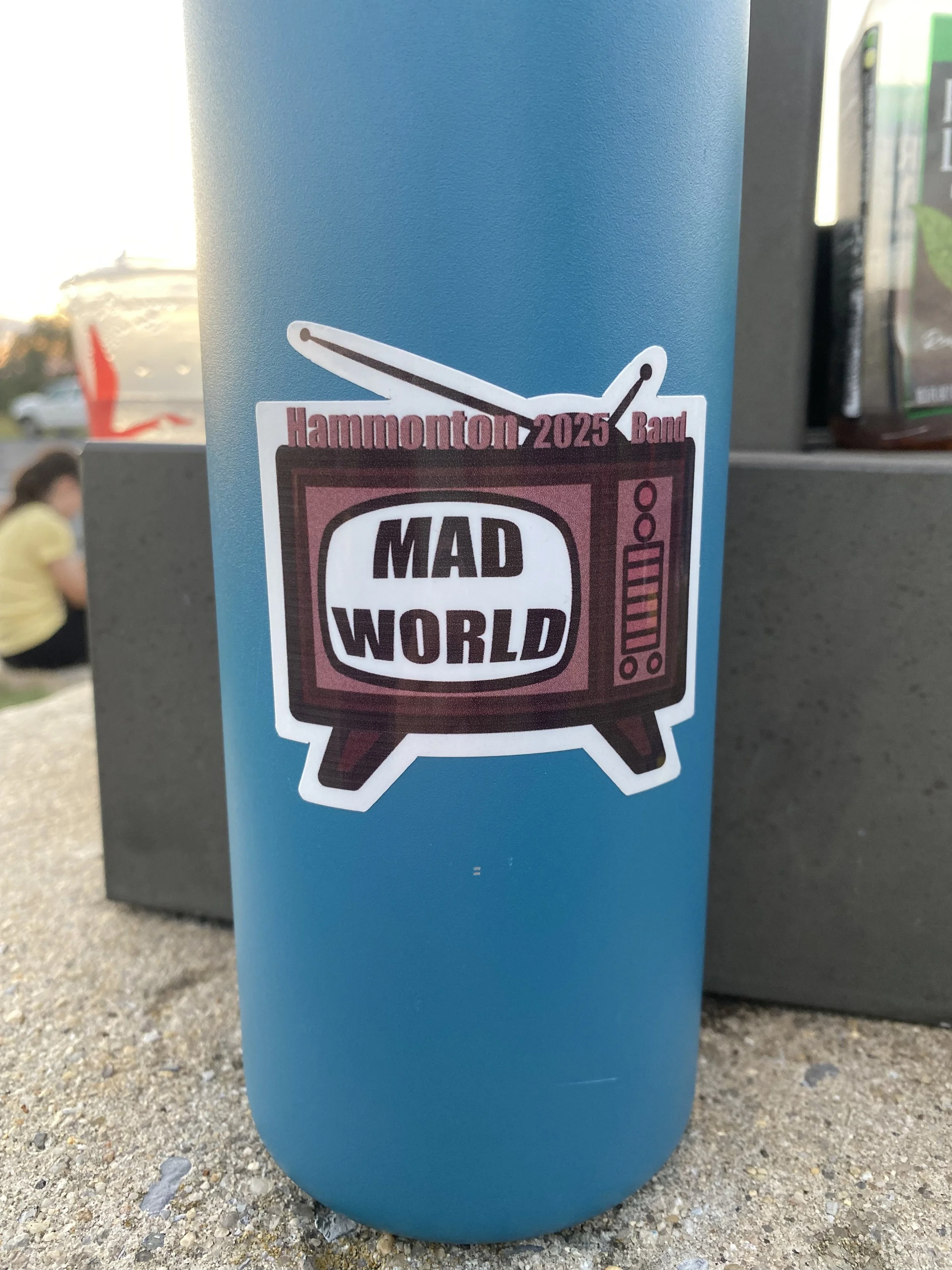 Blue water bottle with sticker showing a vintage television set and text about Hammonton 2025 Band and Mad World.
