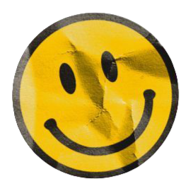 A yellow smiley face sticker with a torn and wrinkled surface.