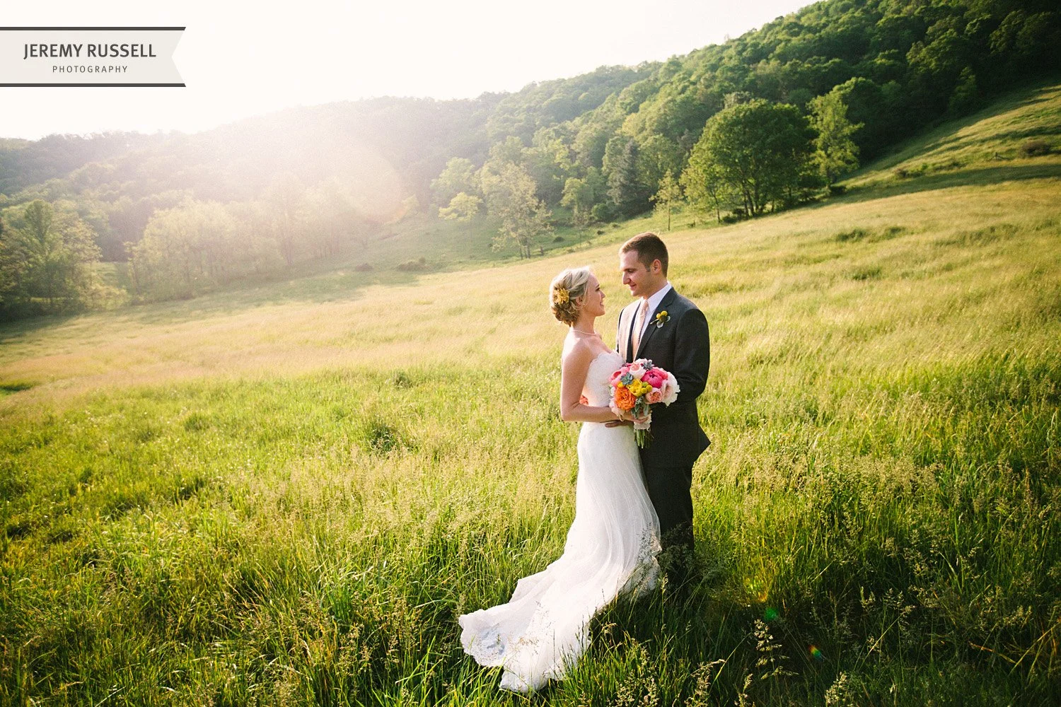 Bride and groom in sunlit field​