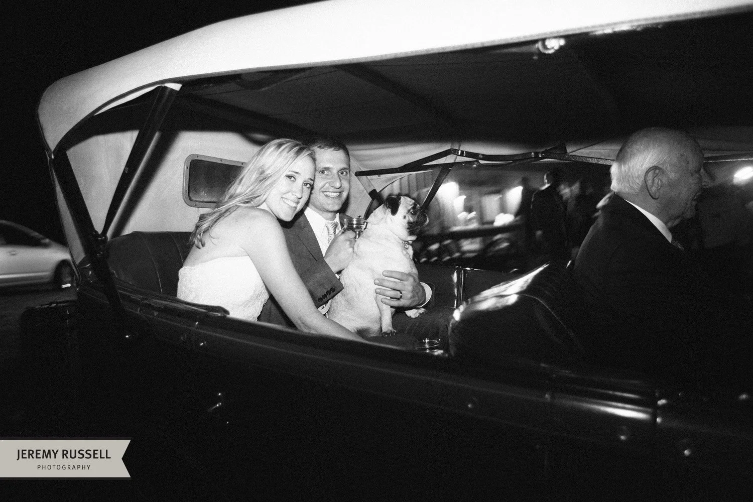 Bride and groom in classic car​