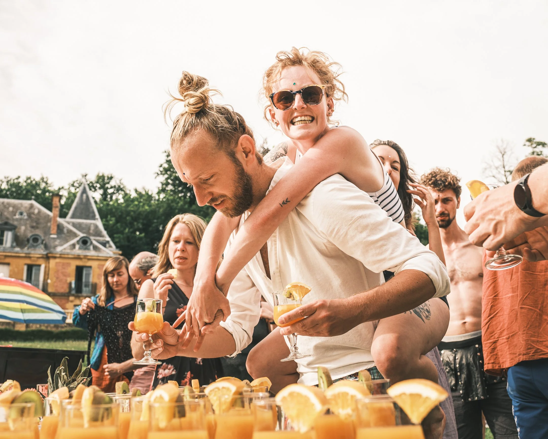 Mensen op een feestje drinken cocktails met sinaasappel en citroen tijdens een zomerdag