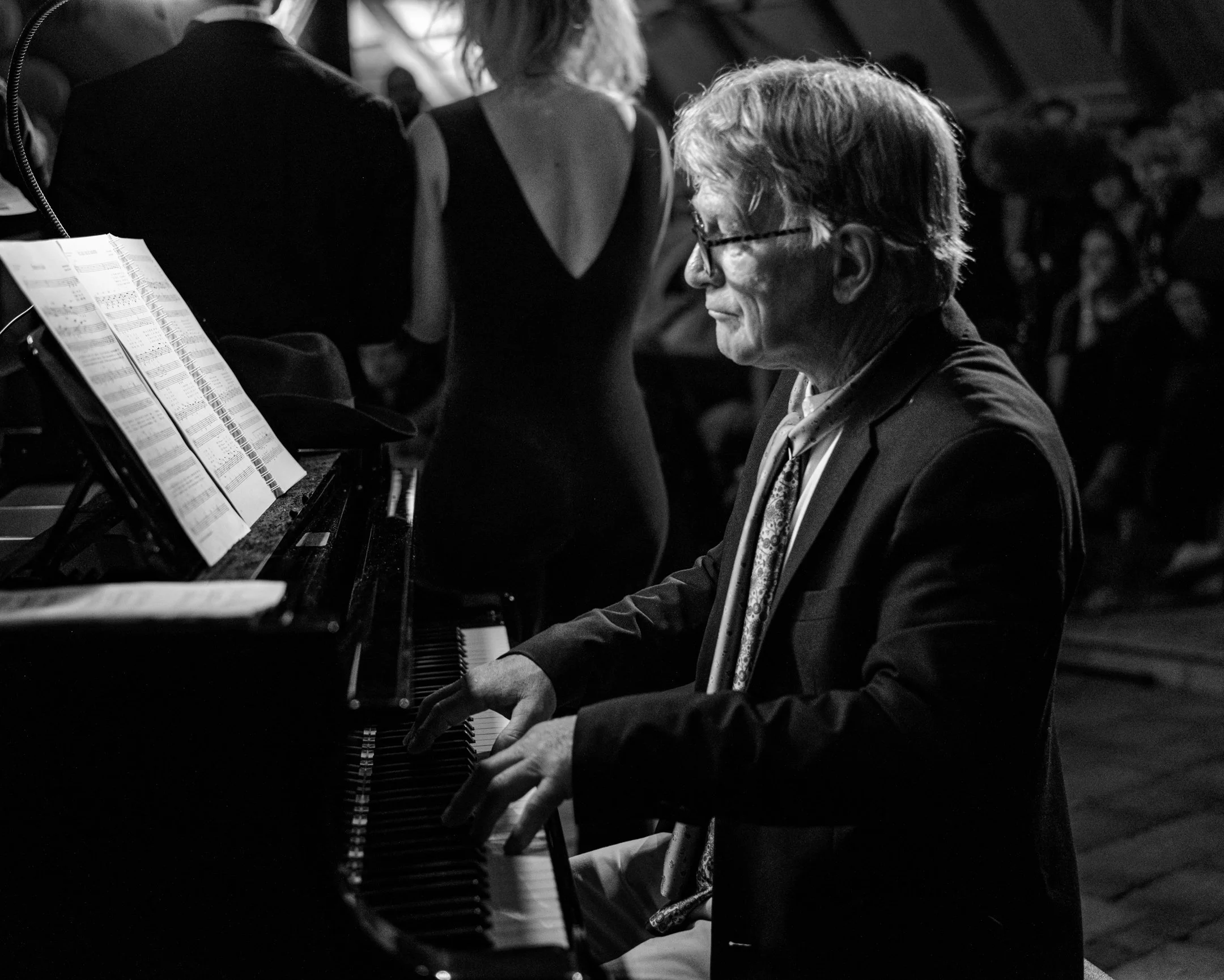 Zweedse pianist speelt piano tijdens een optreden in een donkere setting.