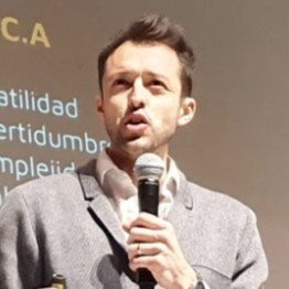 Hombre hablando en un micrófono en una presentación o conferencia