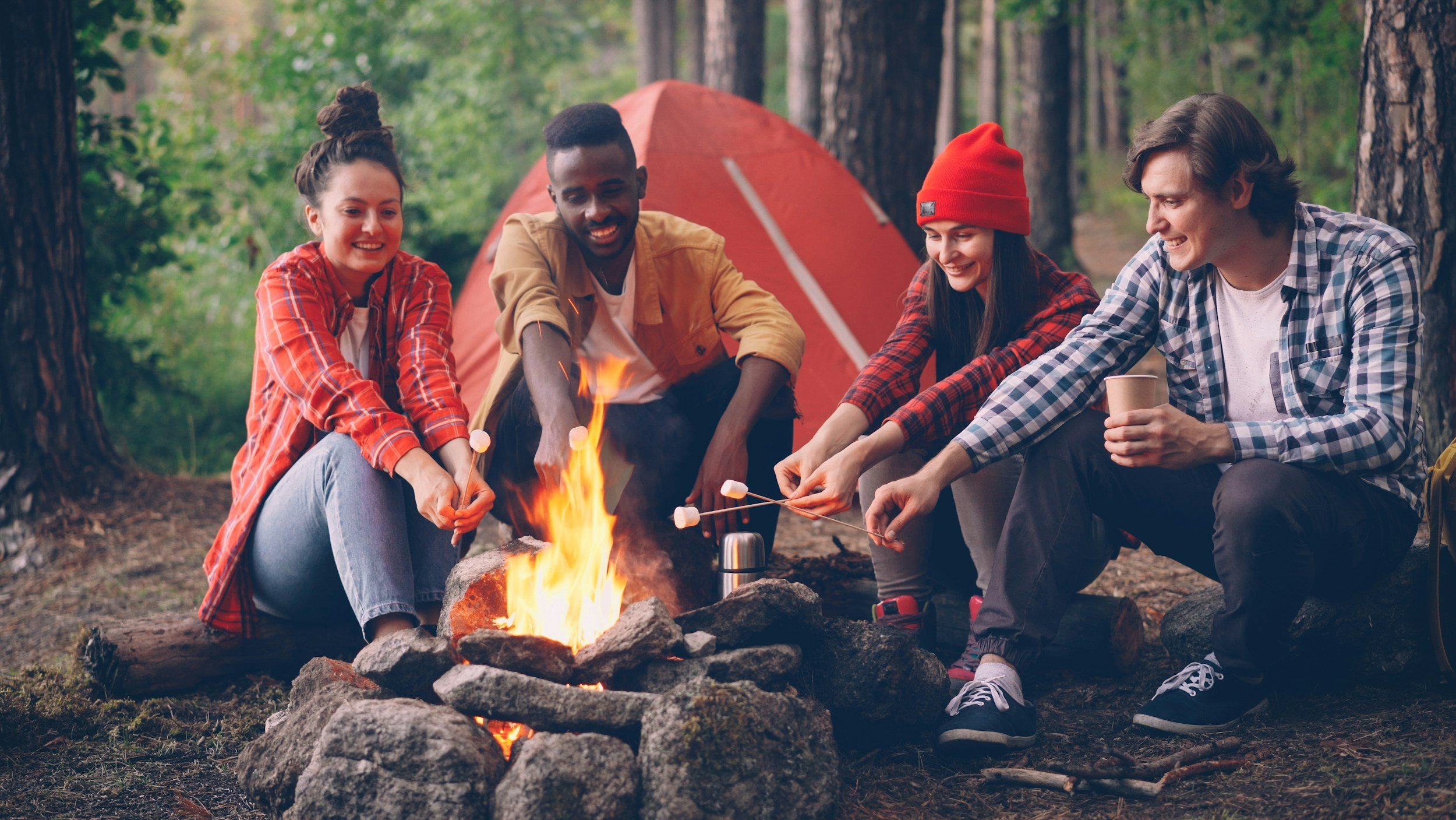 friends around campfire cooking together