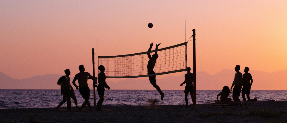 friends playing volleyball in park summer afternoon.png