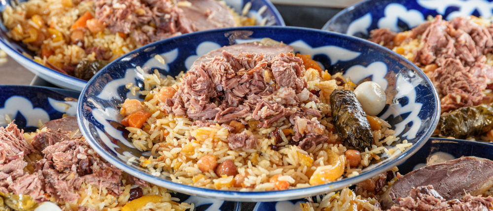 5 Uzbek family-style dinner with plov, fresh bread, grilled meats.png