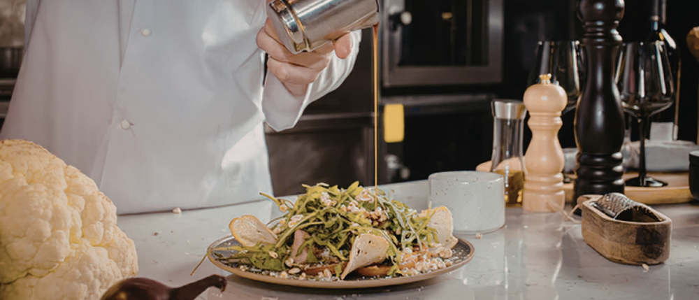 Chef preparing seasonal salad with citrus and herbs.png
