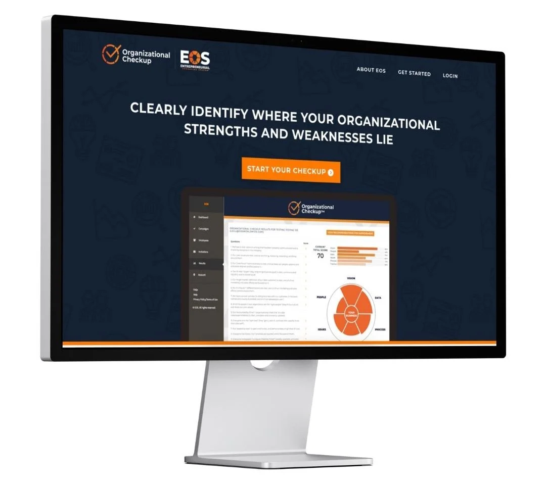 Computer monitor displaying a website titled 'Organizational Checkup' with a tagline about identifying organizational strengths and weaknesses, featuring a prominent orange 'Start Your Checkup' button and a digital report with charts and statistics.