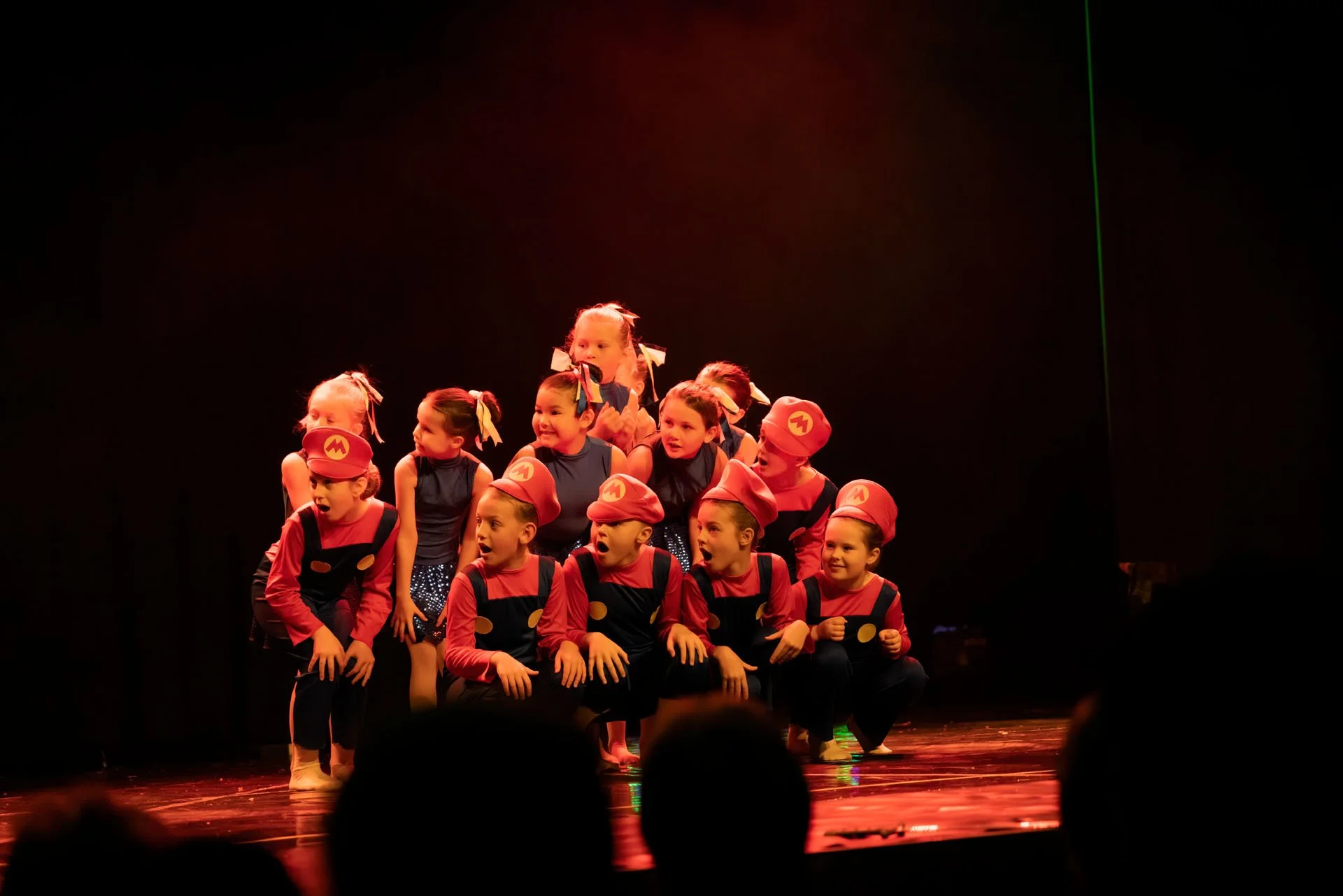 Ei gruppe unger står på ei scene