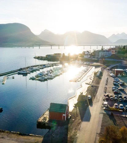 Bilde av småbåthavn i Vestnes med bru, fjell og hav i bakgrunnen