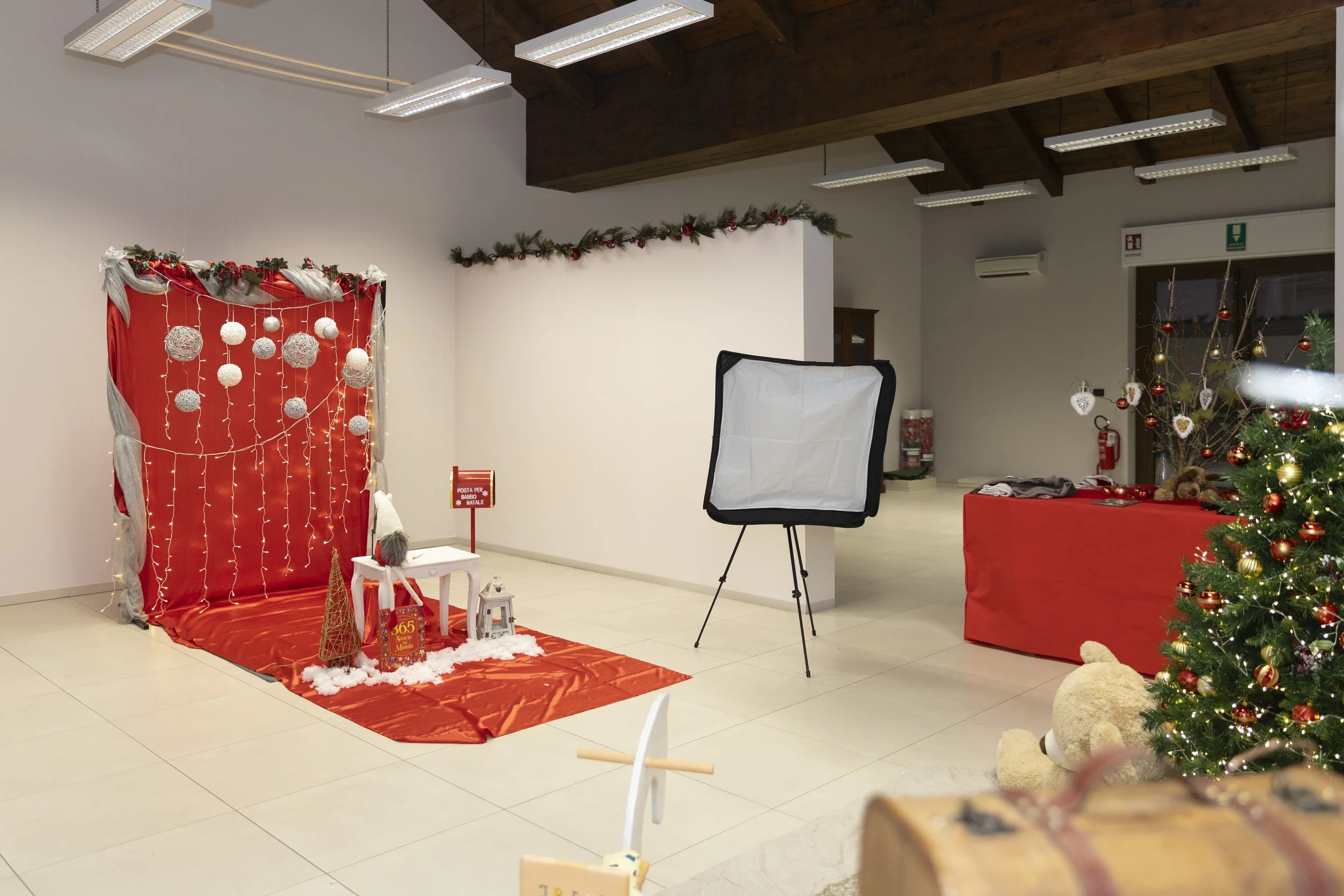 Setup natalizio con decorazioni di Natale, alberi decorati, luci e oggetti festivi in una stanza.