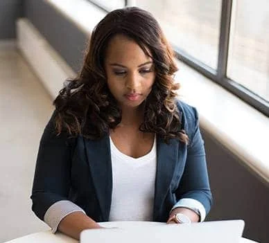 Woman entrepreneur working on laptop managing business overwhelm