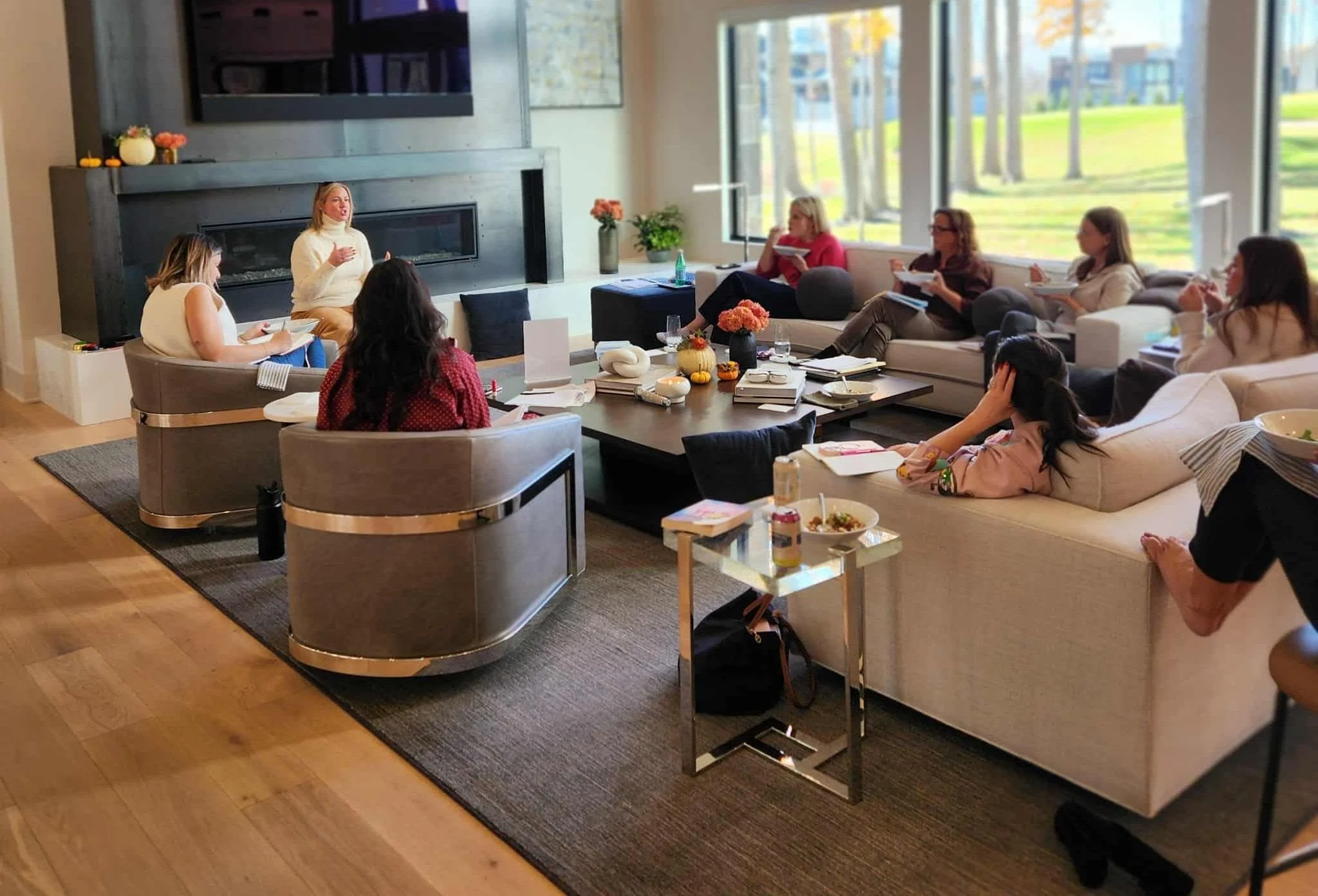 Women listening to a speaker during a small group session in a living room at a She Thinks Big retreat.