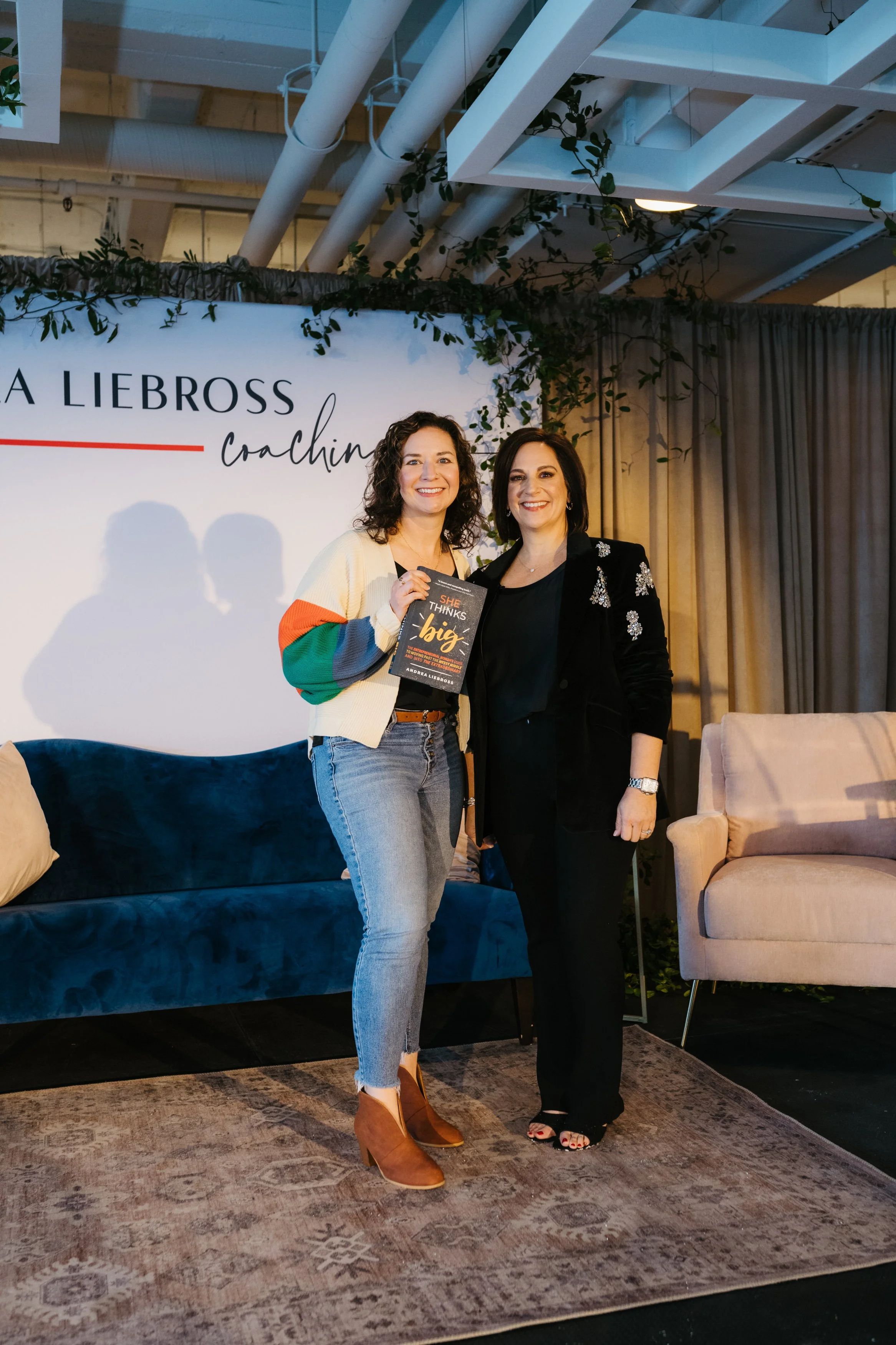 Women entrepreneurs with She Thinks Big book at Andrea Liebross coaching event