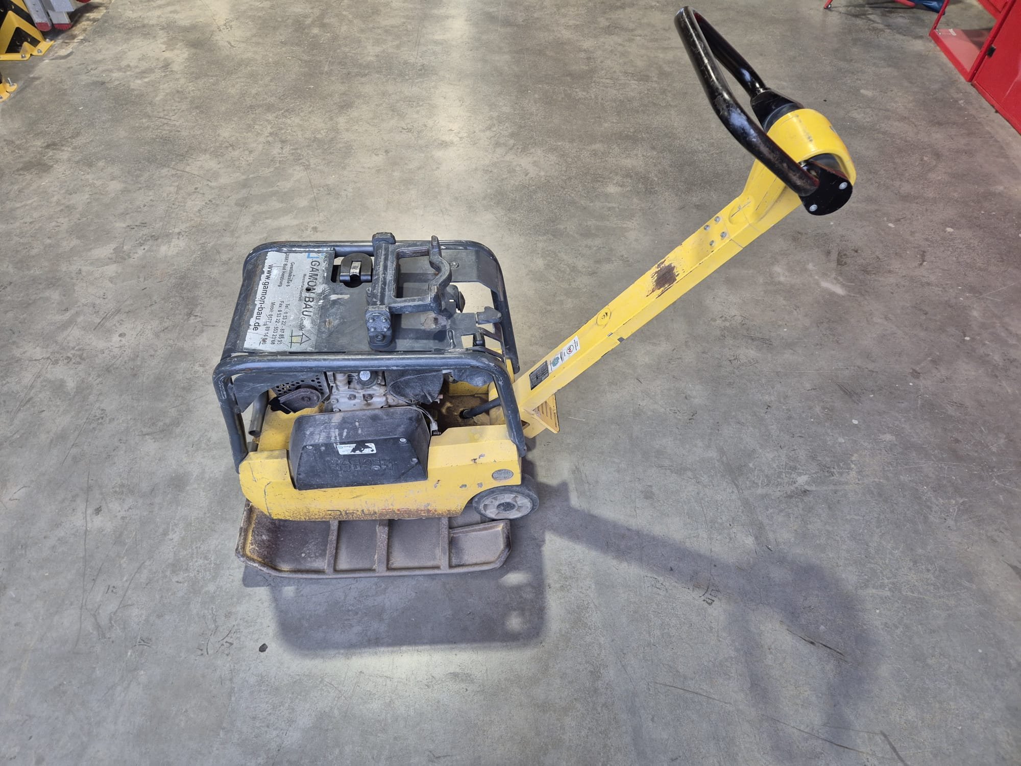 Gelbes Flachstruckturschlaggerät auf einem Betonboden in einer Werkstatt