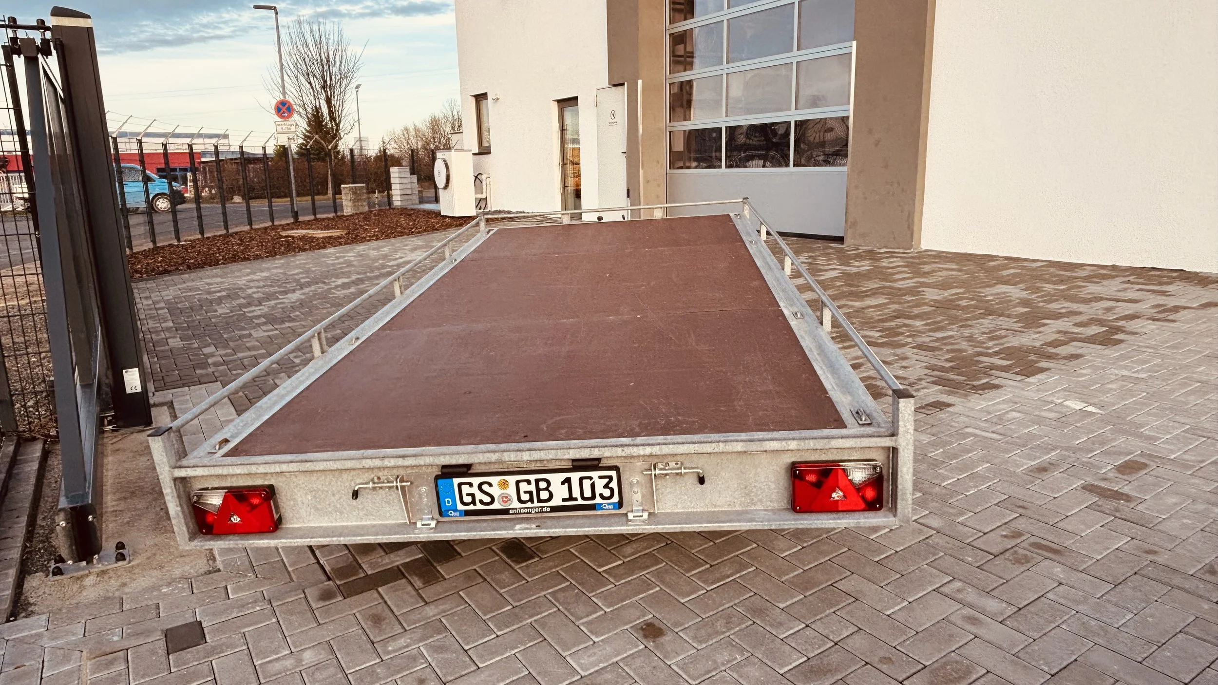 Autotrailer leer auf gepflasterter Fläche.