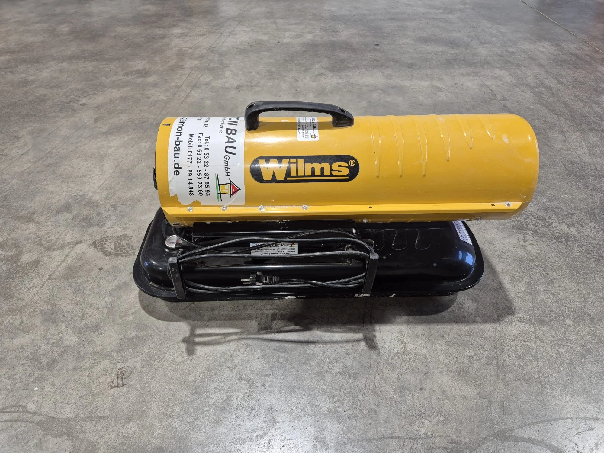 Mobiles Druckluftgerät mit gelber Kompressorkanister und schwarzem Basisgehäuse auf Betondecke.