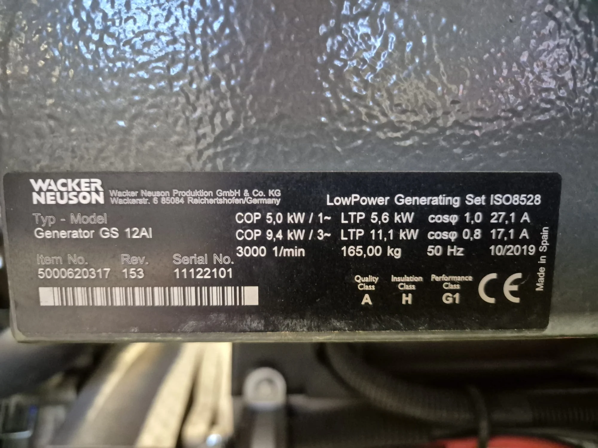 Aufkleber mit technischen Daten eines Generators, Marke Wacker Neuson, Modell GS 12AI, Informationen zu Leistung, Spannung, Frequenz, Gewicht und Herstellungsdatum.