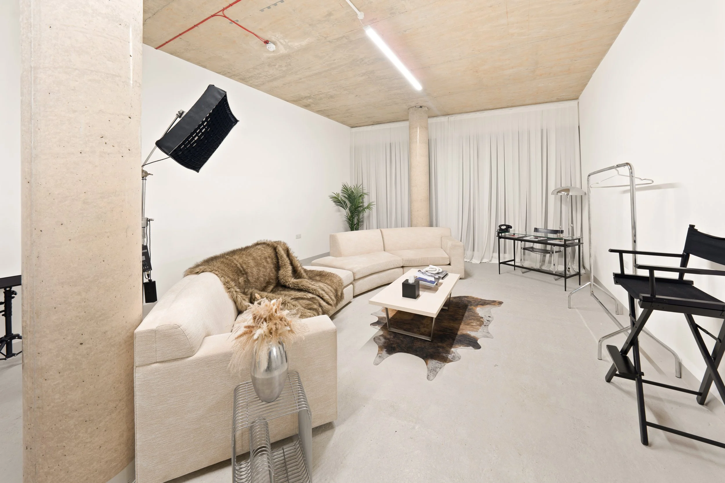 A contemporary lifestyle photography set at URBN Link Studios in East London, featuring a minimalist living room with modern furnishings, neutral décor, large natural light curtains, and professional studio lighting,perfect for branding shoots, lifes