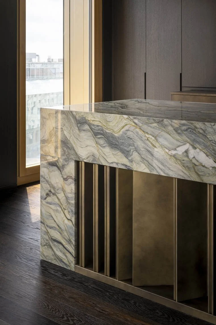Innenraum mit Marmor-Tresen und Holzverkleidung, Blick auf einen Balkon mit Stadtblick.