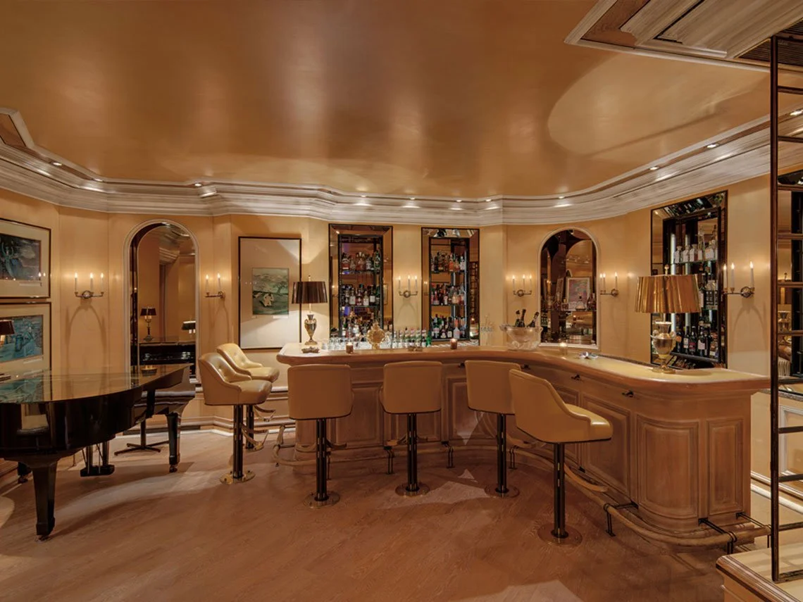 Elegante Hausbar mit Holztheke, barhockern, auserlesener Dekoration und Getränke, in einem stilvoll eingerichteten Raum.