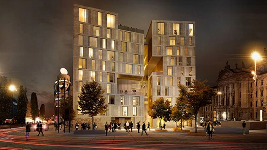 Modernes, mehrstöckiges Gebäude mit vielen Fenstern bei Nacht, umgeben von Menschen und Bäumen, beleuchtet von Straßenlaternen.