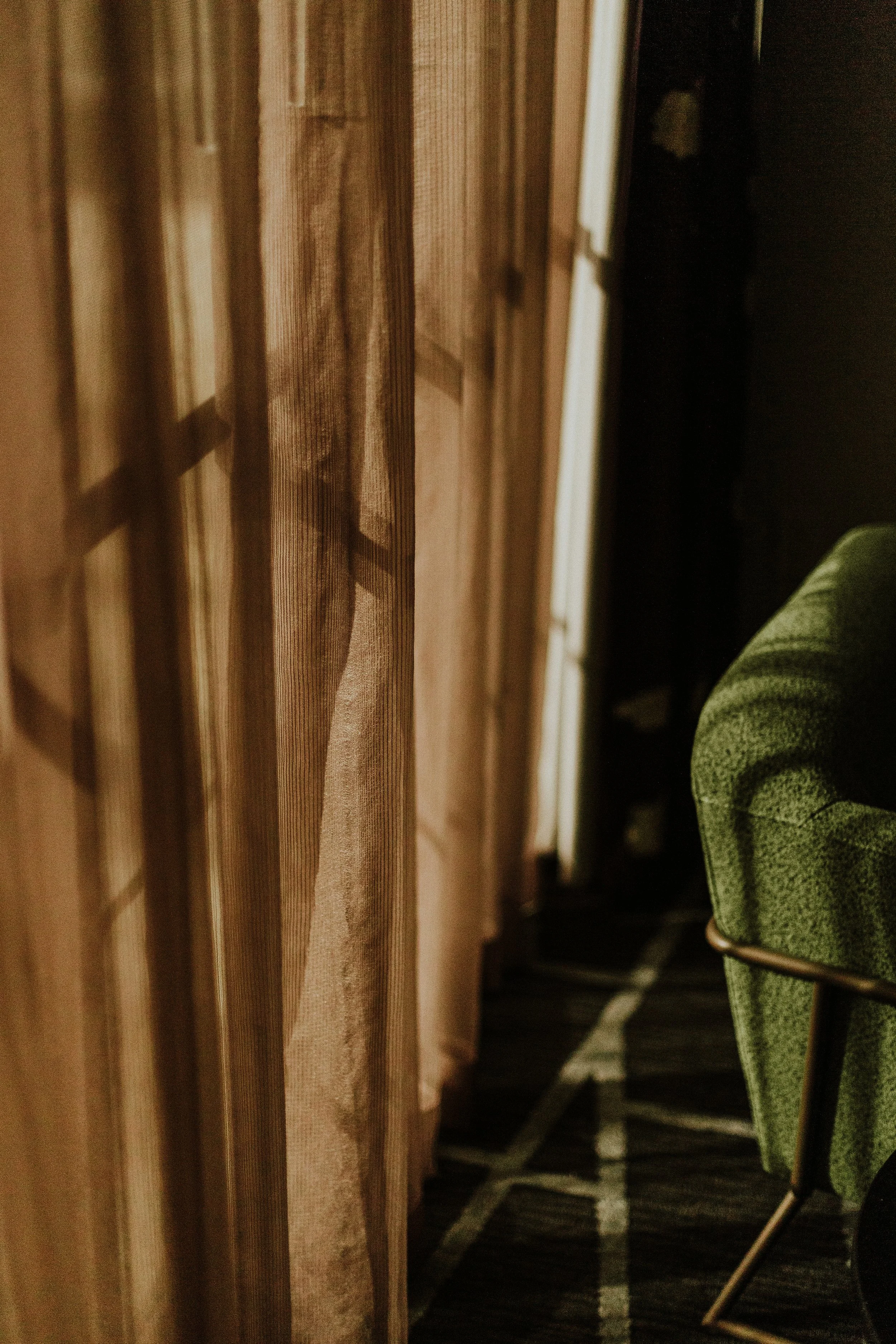 Eine Nahaufnahme eines Holzregals oder einer Holzwand mit einer grünen sitzenden Person im Hintergrund.