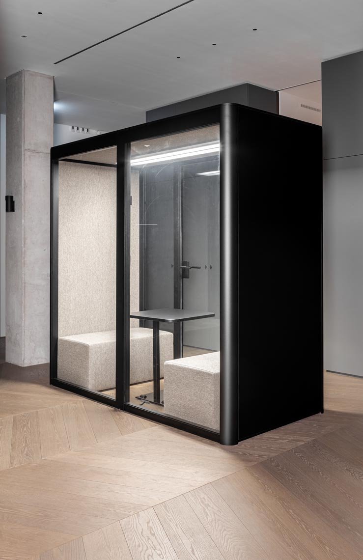 Moderne schalldichte Rückzugskabine mit Sitzbänken und Tisch in einem modernen Büro